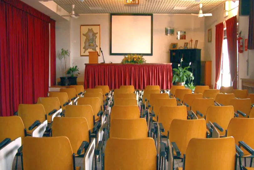 Conference room with seating and stage at the Bahá’í Study Center for corporate events